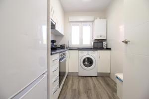 Una cocina blanca con lavadora y secadora. en Apartamento céntrico con aparcamiento en Santander