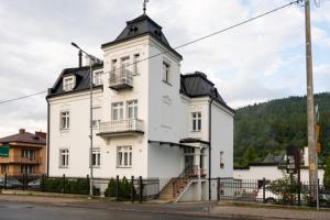 Un grand bâtiment blanc avec un escalier se trouve devant. dans l'établissement Villa Neve, à Ustrzyki Dolne