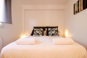 1 dormitorio con 1 cama blanca grande y 2 almohadas en Apartamento céntrico con aparcamiento, en Santander