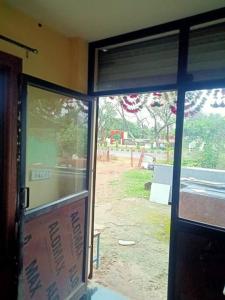 a glass door of a building with a view of a yard at home sweet home in Bhopal