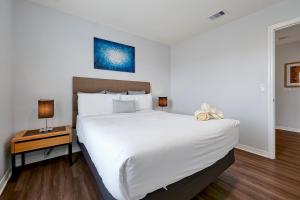 a bedroom with a large white bed and a night stand at Encantada Resort Vacation Townhomes by IDILIQ in Kissimmee