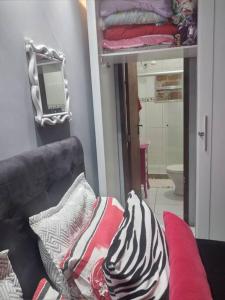 a room with a couch with pillows and a mirror at Casa na melhor praia do Recreio dos Bandeirantes in Rio de Janeiro