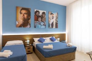 2 letti in una camera con poster appesi al muro di The HeArt Guest House a Napoli