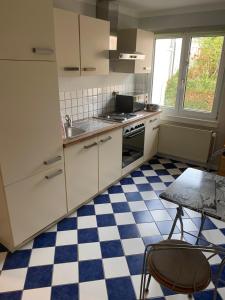 eine Küche mit weißen Schränken und einem karierten Boden in der Unterkunft Casa Türk in Bad Nauheim