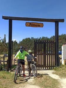 two people on bikes in front of a gate at Aldebarán Farming & Glamping in Duitama