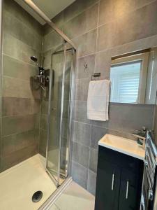 La salle de bains est pourvue d'une douche, d'un lavabo et d'un miroir. dans l'établissement Cozy 2 Bed Room Tufnell Park Haven, à Londres