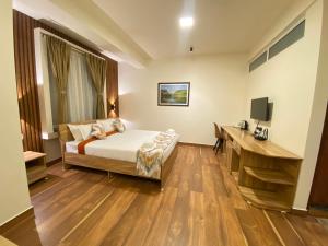 una camera d'albergo con letto e scrivania di Janeira a Shillong