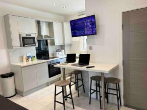 a kitchen with a table with two laptops on it at Cozy 2 Bed Room Tufnell Park Haven in London