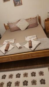 a bed with two pillows and towels on it at Къща за гости в селска местност in Petrich