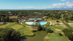 ティレニアにあるCosmopolitan Golf & Beach Resortのリゾート付きのゴルフコースの空中ビュー