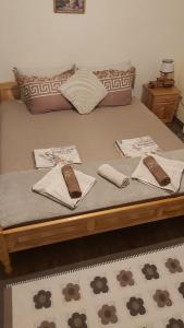 a bed with brown pillows and towels on it at Къща за гости в селска местност in Petrich