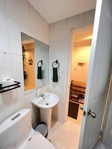 La salle de bains blanche est pourvue d'un lavabo et de toilettes. dans l'établissement Charm’s Place, à Olongapo