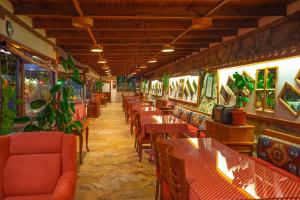 番紅花城的住宿－Cesmeli Konak Corner，餐厅墙壁上摆放着桌椅和植物