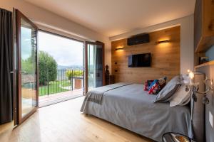 a bedroom with a large bed and a balcony at Cascina Portinale 8 in Alba