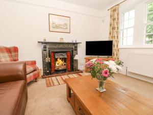a living room with a fireplace and a television at Crookham Dairy in Cornhill-on-tweed