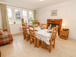 a dining room with a table and chairs and a fireplace at Crookham Dairy in Cornhill-on-tweed