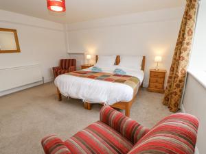 a bedroom with a bed and a couch at Crookham Dairy in Cornhill-on-tweed