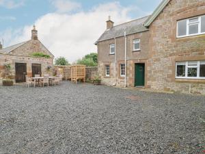a house with a gravel driveway in front of it at Crookham Dairy in Cornhill-on-tweed