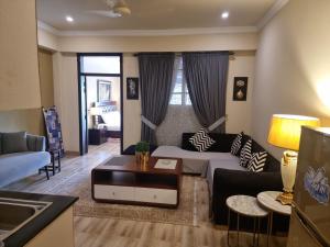 una sala de estar con un sofá y una mesa en SK Lounges Bhurban, en Bhurban