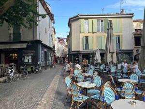 an outdoor cafe with tables and chairs in a street at Maison de village, centre historique in Sérignan
