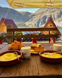 a table with plates of food and cups on it at Kapetanovo Jezero Bungalov in Podgorica