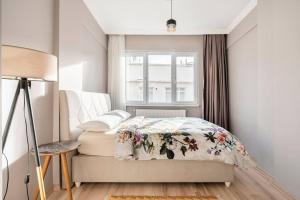 1 Schlafzimmer mit einem Bett mit Blumenbettdecke und einem Fenster in der Unterkunft Pretty house in historical Istanbul district in Istanbul