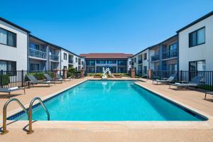 a swimming pool with chairs and a building at Courtyard Fort Worth University Drive in Fort Worth