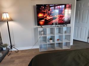 a flat screen tv sitting on top of a white entertainment center at TRANQUIL OASIS - Private Rooms -Near Downtown Indianapolis in Indianapolis