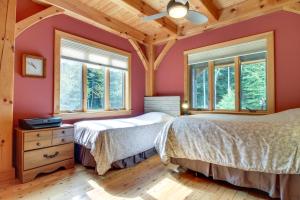 two beds in a bedroom with red walls and windows at Chester Home with Views about 10 Mi to Okemo Mtn Resort! in Chester