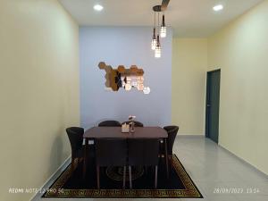une salle à manger avec une table et des chaises noires dans l'établissement Loving Homestay, à Kuantan