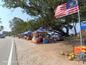 un marché en plein air avec drapeau américain sur le côté de la route dans l'établissement Loving Homestay, à Kuantan