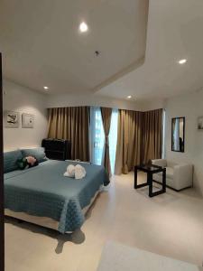 Lovely Room في Maribago: غرفة نوم كبيرة مع سرير أزرق وأريكة