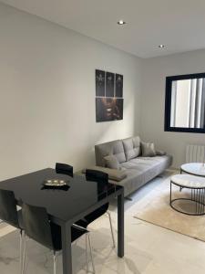 a living room with a black table and a couch at Tunis Résidence california in Al Karm