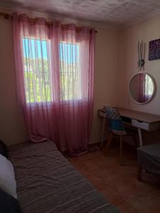 a bedroom with a desk and a window with pink curtains at Casa Olga. This is your holiday Rest with pleasure in Benissa