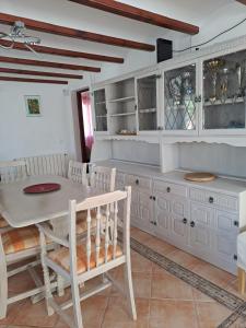 a kitchen with white cabinets and a table and chairs at Casa Olga. This is your holiday Rest with pleasure in Benissa