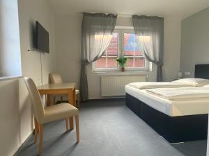a bedroom with a bed and a desk and a window at Berghotel Sülbeck in Nienstädt +51 photos