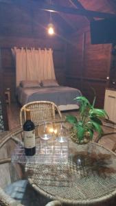 南河的住宿－Chalé Sitio do Schlatter，一间设有一张桌子、一瓶葡萄酒和一张床的客房