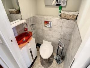 uma casa de banho com um lavatório vermelho e um WC. em Beach Penthouse with unique rooftop terrace 301 em Cannes