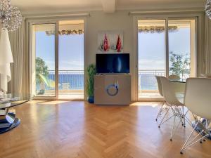 uma sala de estar com televisão e uma mesa com cadeiras em Beach Penthouse with unique rooftop terrace 301 em Cannes