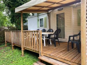 eine Holzterrasse mit einem Tisch und Stühlen darauf in der Unterkunft MORREALE MOBILE HOME (prox. Europa park/Rulantica) in Boofzheim