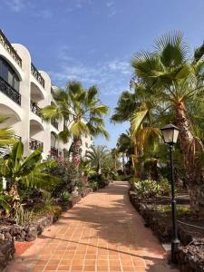 a brick walkway with palm trees and a street light at Opuncja Apartament in San Miguel de Abona