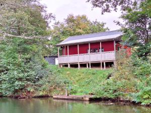 a red house on a hill next to a river at Brinken at Ry in Ry