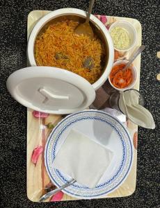 斯利那加的住宿－HOTEL MERLIN PALACE，餐桌,餐桌上放着一壶食物和一盘食物