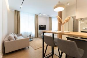 eine Küche und ein Wohnzimmer mit einem Tisch und Stühlen in der Unterkunft Olive Apartments in Belgrad