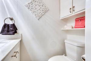 a white bathroom with a toilet and a sink at Kingston Cabin Rental Walk to Lake Texoma Beaches in Shay +17 photos