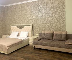 - une chambre avec un lit et un canapé dans l'établissement Gandzak Hotel, à Vanadzor