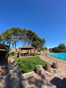 einen Picknickbereich mit einem Pavillon neben einem Pool in der Unterkunft Villa Entrenaranjos in Picassent