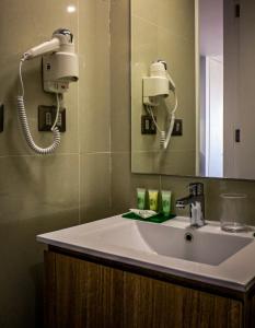 baño con lavabo, espejo y teléfono en EcoApart Antofagasta, en Antofagasta