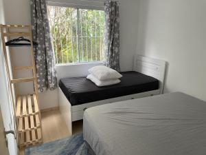 um pequeno quarto com uma cama e uma janela em Casa do Marisco Experience na Praia dos Ingleses em Florianópolis