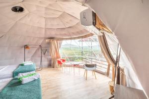 Habitación con cama y ventana grande. en Glamping en Playa Potrero en Potrero